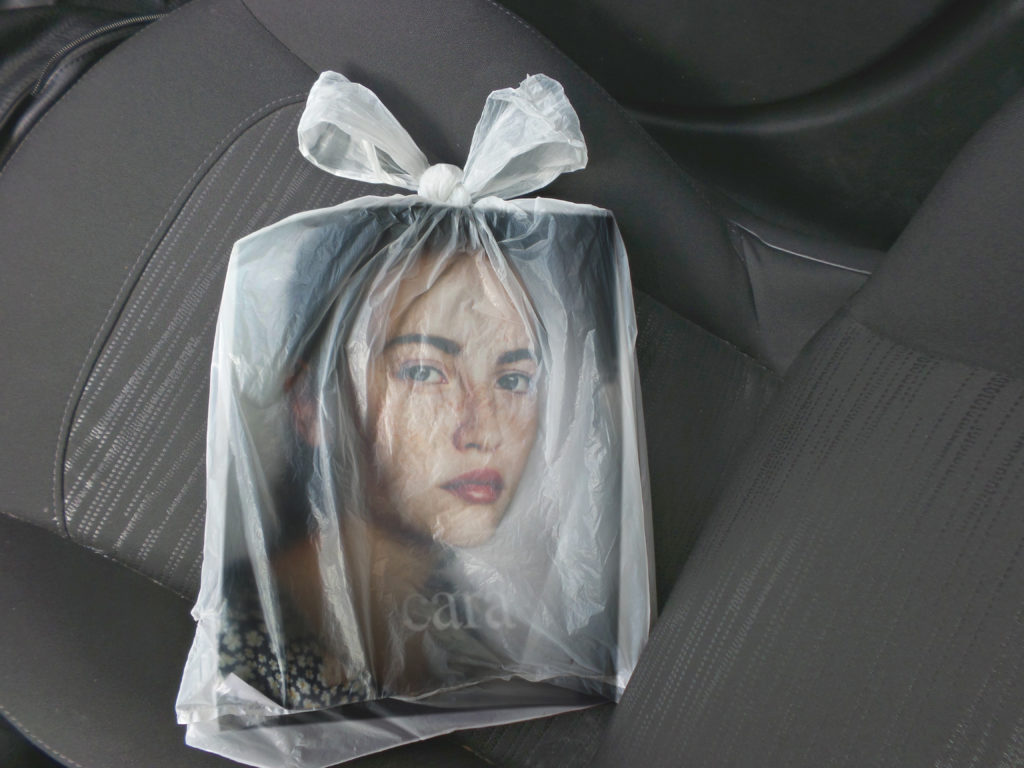 Magazine de mode dans un sac en plastique transparent posé sur un siege de voiture