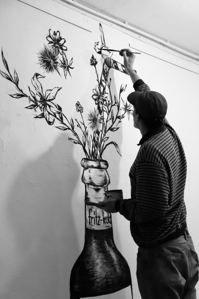 le street artiste kraken peinant une fresque pour fritz kola